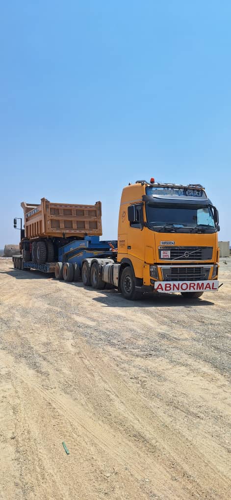 Volvo truck hauling heavy equipment on lowbed trailer